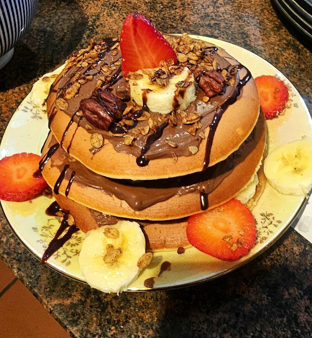 Pancake-Turm mit Schokoladencreme, Bananen, Erdbeeren und Pekannüssen