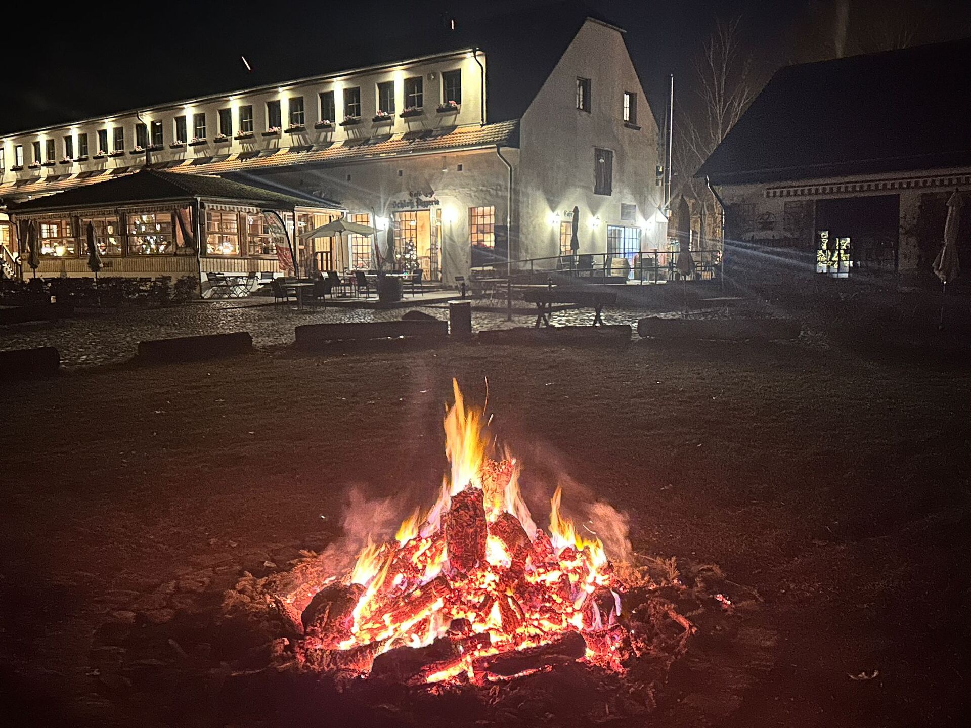 Lagerfeuer im Hof am Abend vor dem historischen Gebäude