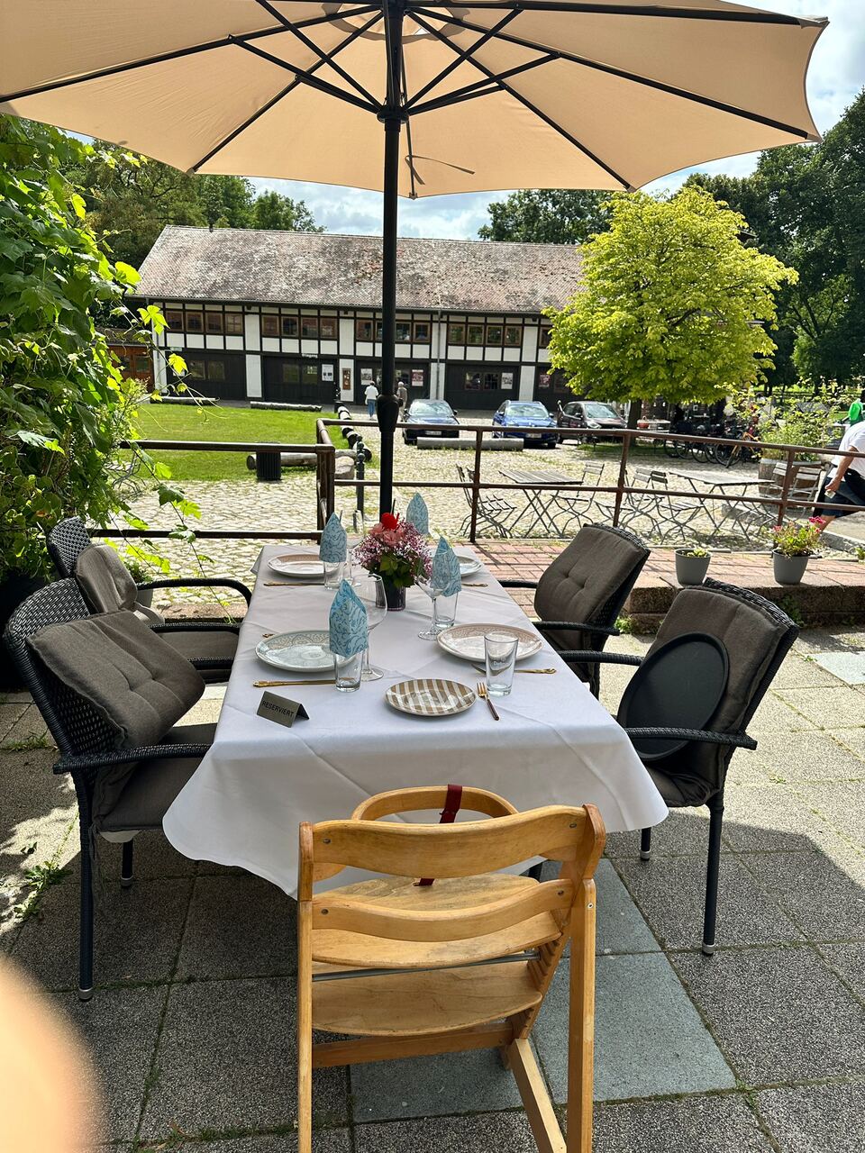 Sonnige Terrasse mit Sonnenschirm und Blick auf den historischen Hof