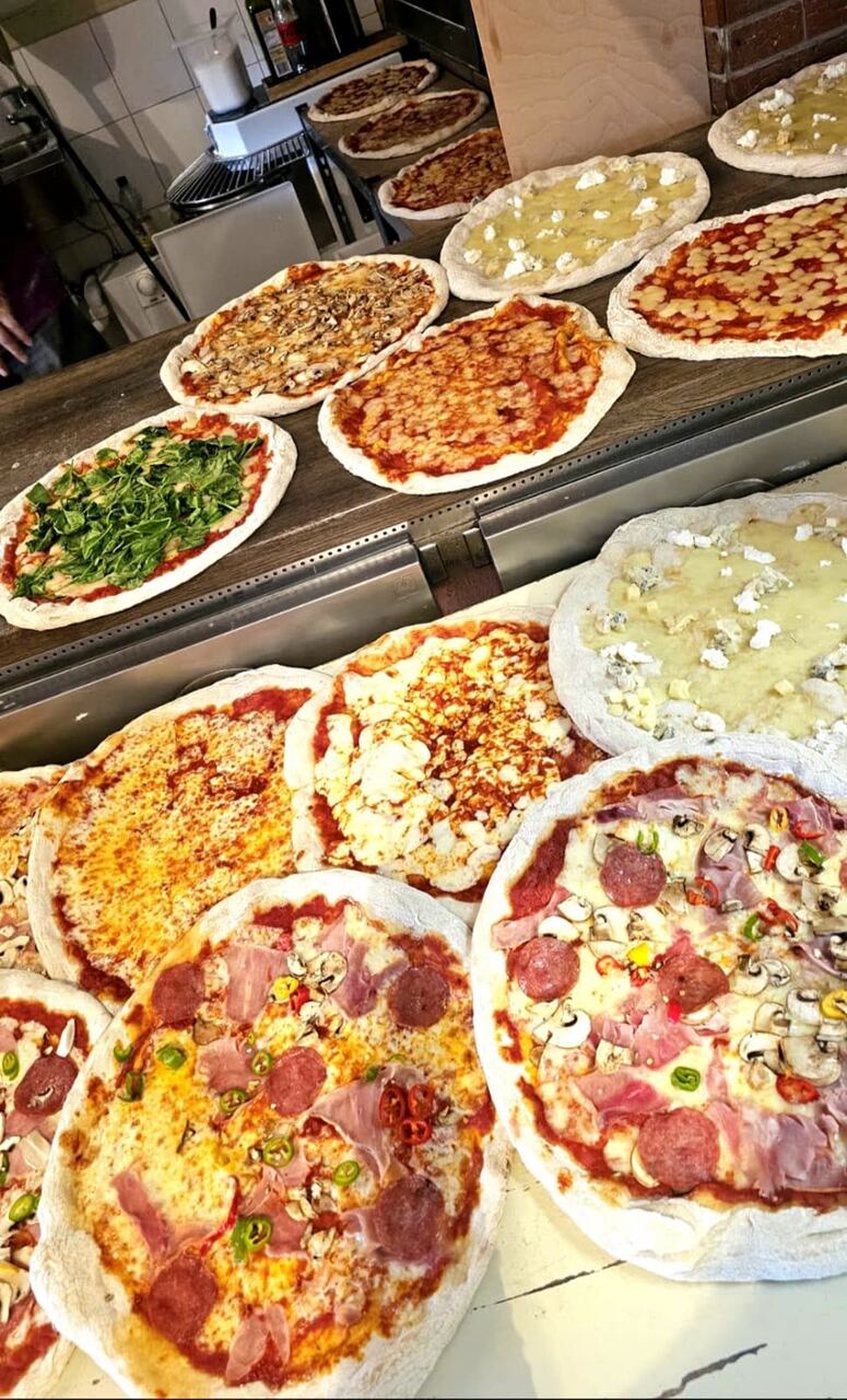 Frische Steinofen-Pizzen in der Auslage unseres Cafés